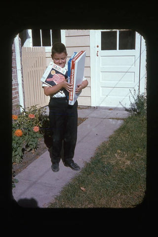 YOUNG BOY ON WALKWAY WITH ARMS FULL OF BOARD GAMES 1960's PHOTO SLIDE Model