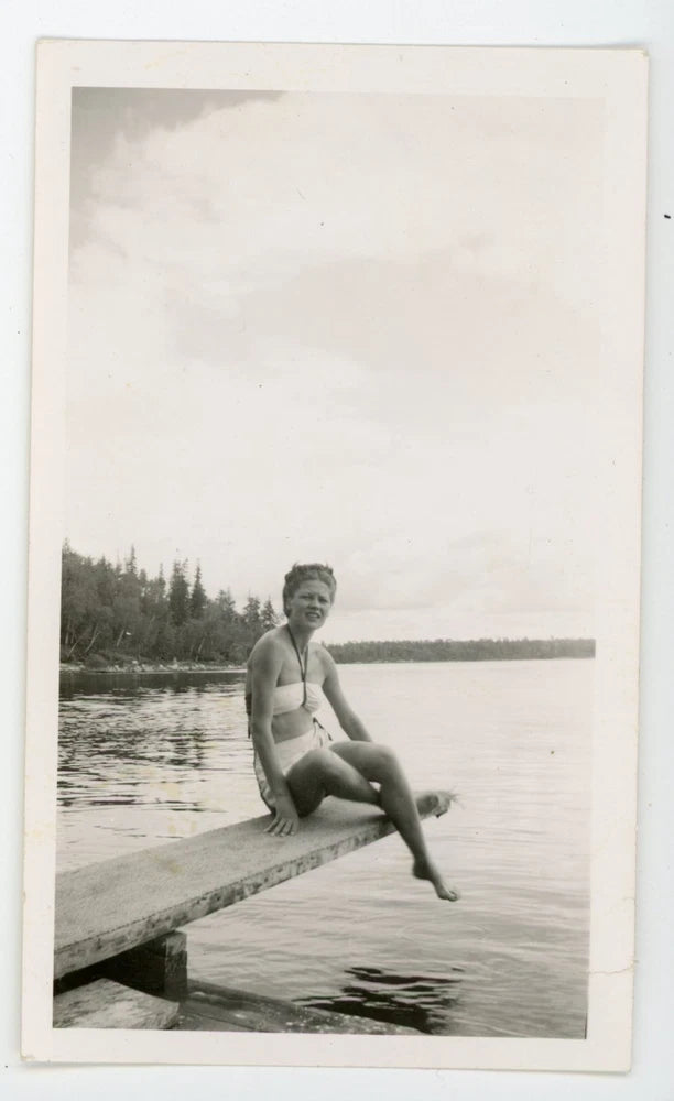 Pretty girl in bathing suit sitting on diving board.  Vintage snapshot photo Model