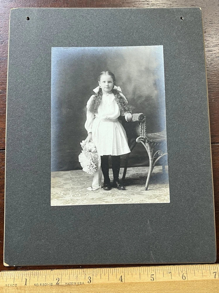 Photo on Board,  Young Girl with Long Hair, Bows and Holding a Floral Hat. 1906 Model